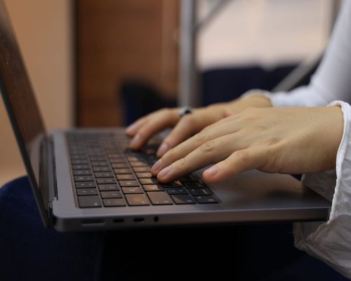 Close up of hands typing on a modern laptop keyboard